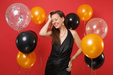 Siyah elbise kutlayarak kapalı gözler gülümseyen genç kızla, 