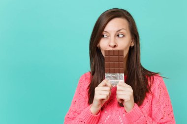 Örgü pembe kazak bakan genç ve güzel kadın bir kenara tutun