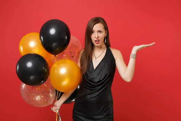 Desconcertado joven mujer en pequeño vestido negro celebrando puntin — Foto de Stock