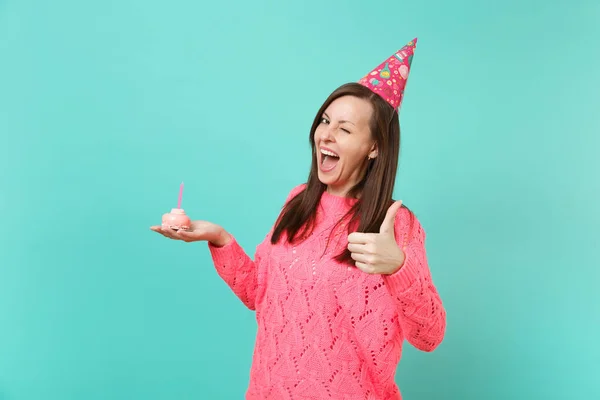 Funny young girl in knitted pink sweater birthday hat blinking s — Stock Photo, Image