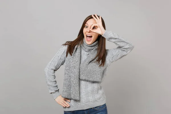 Ενθουσιασμένος για νεαρή γυναίκα σε γκρι πουλόβερ, κασκόλ δείχνει εντάξει χειρονομία ne — Φωτογραφία Αρχείου