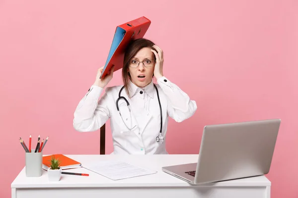 Жінка-лікар за столом працює на комп'ютері з медичним документом — стокове фото