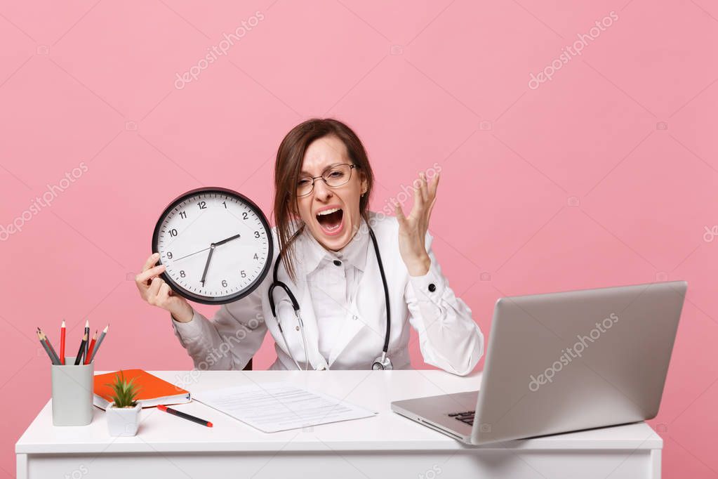 Female doctor sit at desk work on computer with medical document