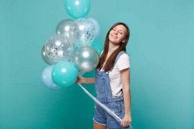 Gözlerini tutmak denim giysiler içinde rahat gülümseyen genç kadın kapalı