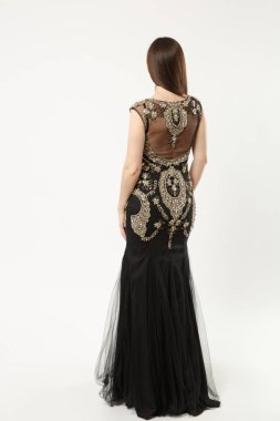 Şık Abiye siyah elbise poz izole beyaz duvar arka plan stüdyo portre üzerinde giyen kadın moda modeli tam uzunlukta fotoğraf. Esmer uzun saçlı kız. Kopyalama alanı alay. Arka arka görünüm.