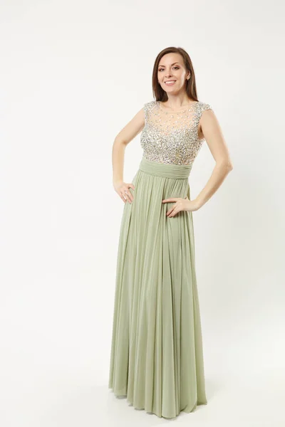 Full length photo of fashion model woman wearing elegant evening dress gown posing isolated on white wall background studio portrait. Brunette long hair girl. Mock up copy space. Olive dress face view — Stock Photo, Image