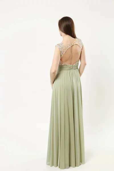 Full length photo of fashion model woman wearing elegant evening dress olive gown posing isolated on white wall background studio portrait. Brunette long hair girl. Mock up copy space. Back rear view. — Stock Photo, Image