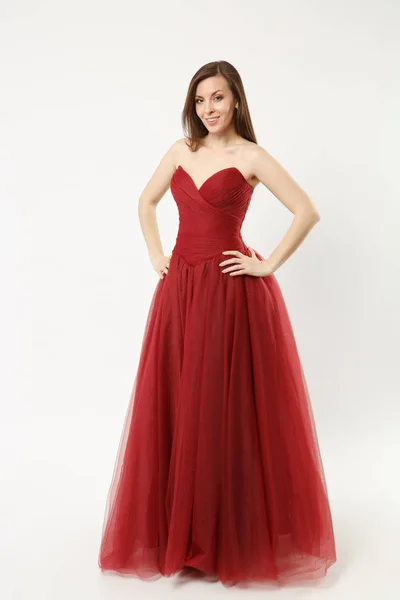 Full length photo of fashion model woman wearing elegant evening dress gown posing isolated on white wall background studio portrait. Brunette long hair girl. Mock up copy space. Red dress face view. — Stock Photo, Image