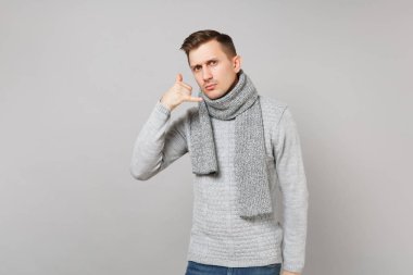 Genç adam gri süveterli eşarp gibi telefon jest yapıyor c diyor.