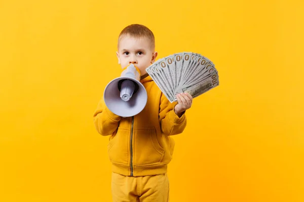 Pequeno menino feliz em roupas amarelas segurar fã de dinheiro em boneca — Fotografia de Stock