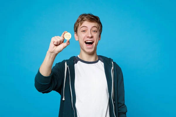 Portrét veselý mladý muž v neformálním oblečení drží bitcoin — Stock fotografie