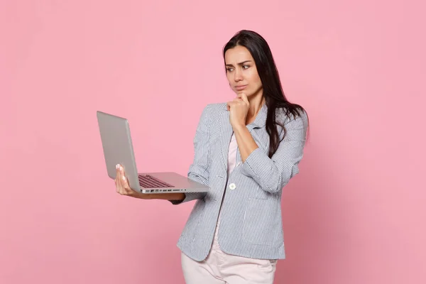 Puzzled jeune femme en veste rayée en utilisant ordinateur portable PC p — Photo