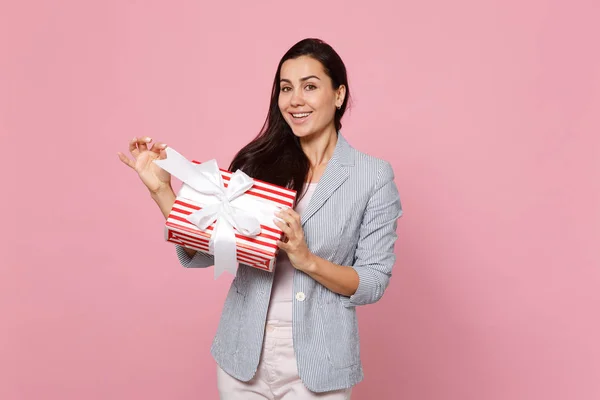Atractiva mujer joven sosteniendo caja de regalo de rayas rojas con regalo — Foto de Stock