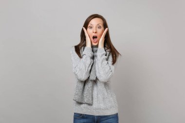 Gri kazak şok genç kadın, eşarp ağız geniş op tutmak