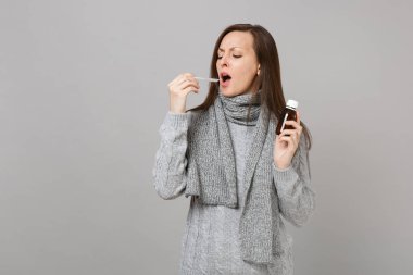 Gri kazak hasta genç kadın, eşarp tutan sıvı Medi dökün