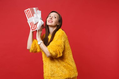 Pensive meraklı genç kadın tutan kırmızı çizgili mevcut kutu ile