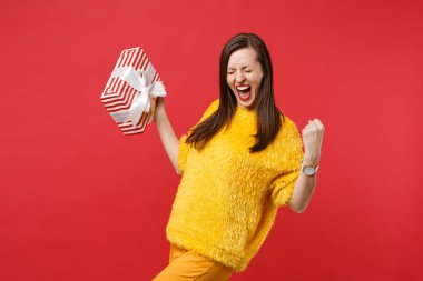 Mutlu genç kadın çığlık, kazanan jest yapıyor, kırmızı s tutarak