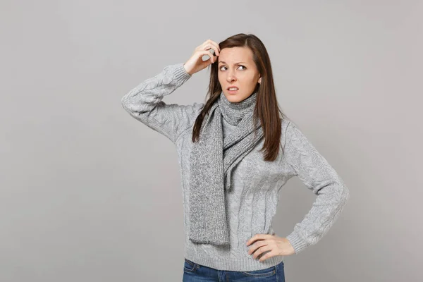 Pensive femme concernée en écharpe pull gris regardant vers le haut tenant — Photo