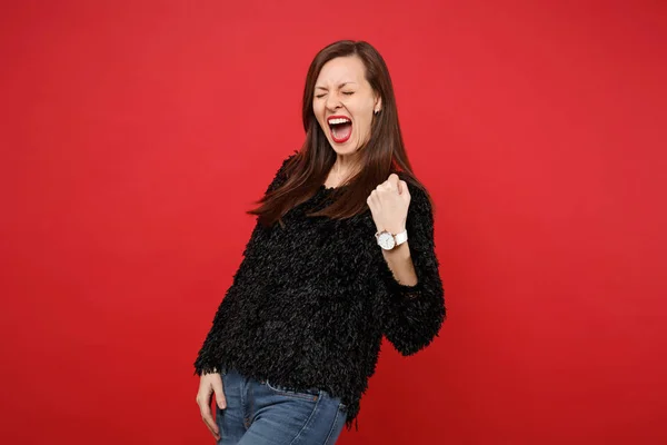 Jovencita llena de alegría en suéter de piel negra haciendo gesto ganador , — Foto de Stock