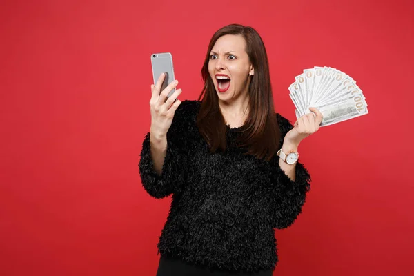 Screaming jonge vrouw in bont trui op zoek op mobiele telefoon hol — Stockfoto
