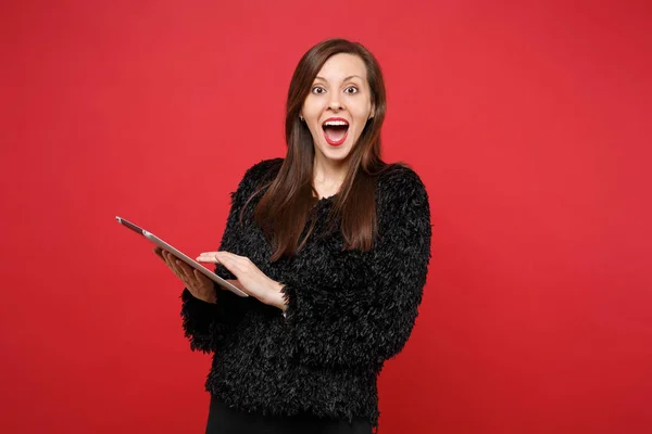 Sorpresa giovane donna in maglione di pelliccia nera mantenendo la bocca larga op — Foto Stock