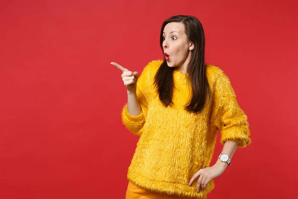Sorprendido mujer joven sorprendida en suéter de piel amarilla buscando, pointi — Foto de Stock