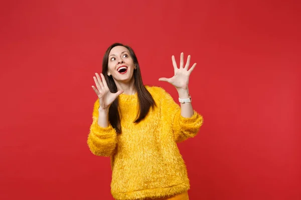 Mujer joven asombrada en suéter de piel amarilla manteniendo la boca abierta — Foto de Stock