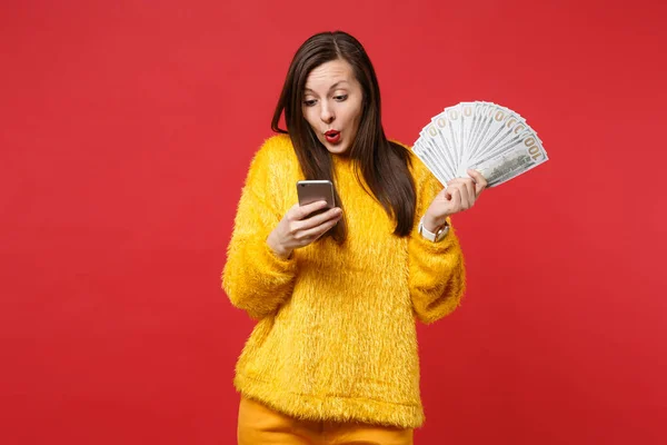 Προβληματισμένος νεαρή γυναίκα με γούνα πουλόβερ κοιτάζοντας το κινητό τηλέφωνο, κρατήστε — Φωτογραφία Αρχείου