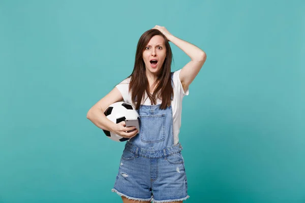 Шокированная нервная женщина футбольный болельщик с футбольным мячом с помощью мобильного — стоковое фото