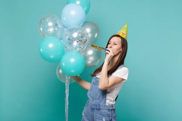 Divertido lindo joven en sombrero de cumpleaños mirando a un lado soplando en —  Fotos de Stock