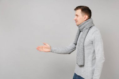 Gri kazak genç adam yan görünümü, çıkışları ile ayakta eşarp