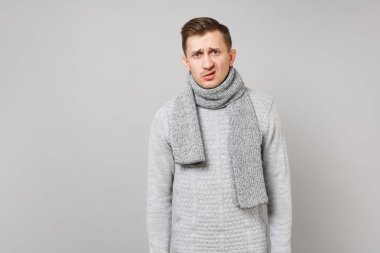 Gri kazak, eşarp ayakta isol içinde şaşkınlık iğrendi genç adam