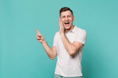 Rahat giysiler bir kenara işaret parmağında gülüyor genç adam