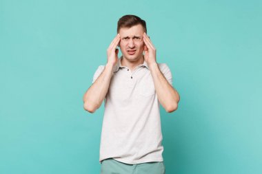 Rahat giysiler içinde baş ağrısı olan yorgun genç adam bitkin