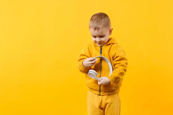 Niño pequeño de 3-4 años con ropa amarilla en los auriculares — Foto de Stock