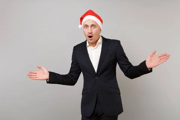 Shocked joven hombre de negocios en sombrero de Navidad extendiendo las manos, kee — Foto de Stock