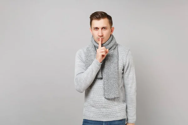 Joven con suéter gris, bufanda diciendo silencio, callado con los dedos — Foto de Stock