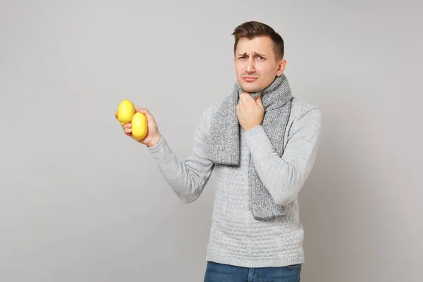 Utmattad ung man i grå tröja, halsduk sätta handen på throa — Stockfoto