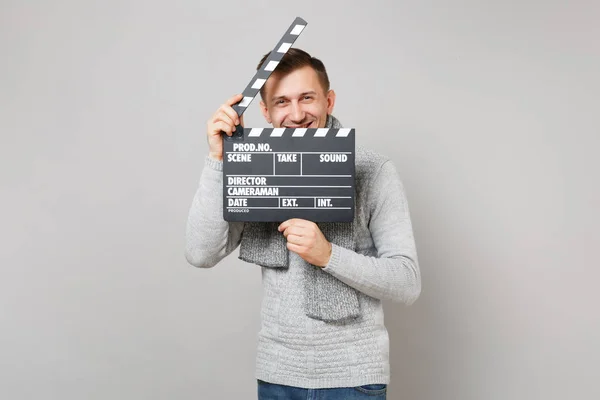 Cheerful young man in gray sweater, scarf hiding behind classic — Stock Photo, Image