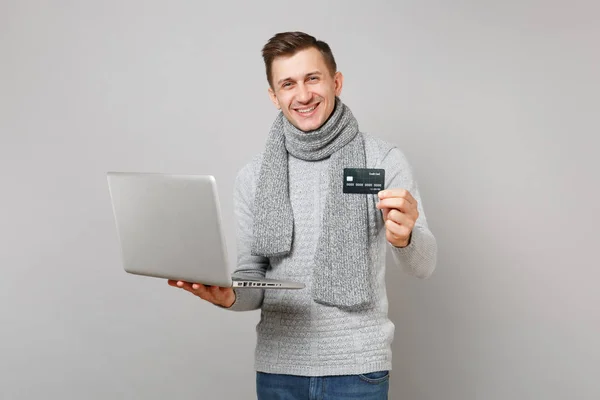 Sorrindo jovem em camisola cinza, lenço segurar cartão de crédito , — Fotografia de Stock