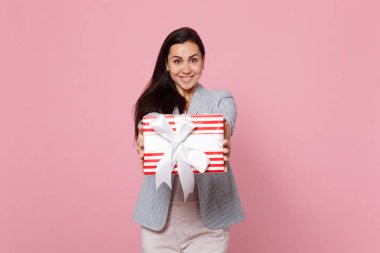 Joyful young woman holding red striped present box with gift rib