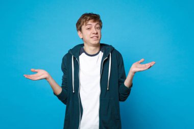 Rahat kıyafetler yayıldı şaşkın gülümseyen genç adam portresi