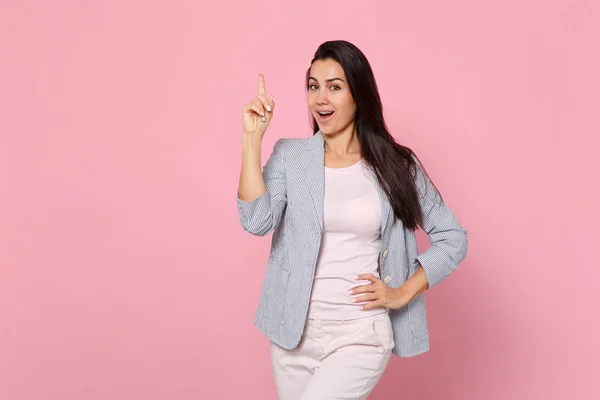 Portrait of excited young woman in striped jacket holding index