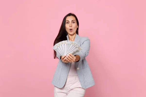 Geschokte jonge vrouw met geopende mond Holding fan van geld in te doen — Stockfoto