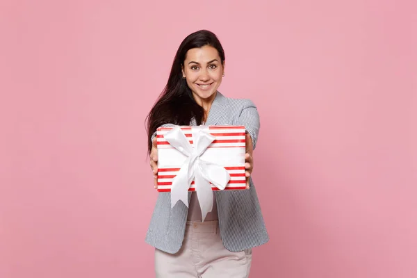 Joyful young woman holding red striped present box with gift rib — Stok fotoğraf