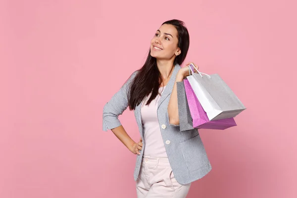 Joyful jovem mulher em jaqueta listrada olhando para o lado, segurando pack — Fotografia de Stock