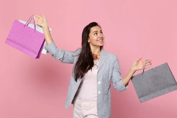 Joyeuse jeune femme en veste rayée regardant de côté, tenant pack — Photo