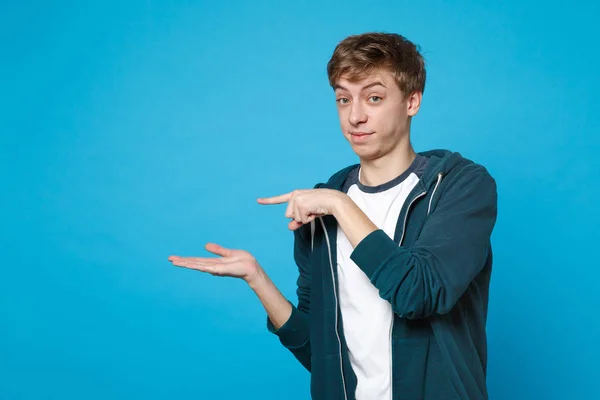 Retrato de un joven desconcertado con ropa casual señalando la mano — Foto de Stock