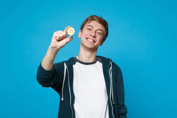 Retrato de un joven sonriente con ropa casual sosteniendo bitcoin , —  Fotos de Stock