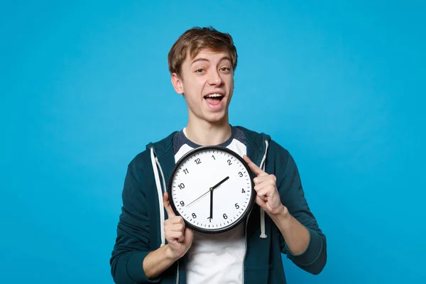 Portrait of excited young man in casual clothes holding round cl — Stock Photo, Image
